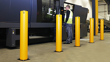 Industrial safety bollard protecting machinery in warehouse